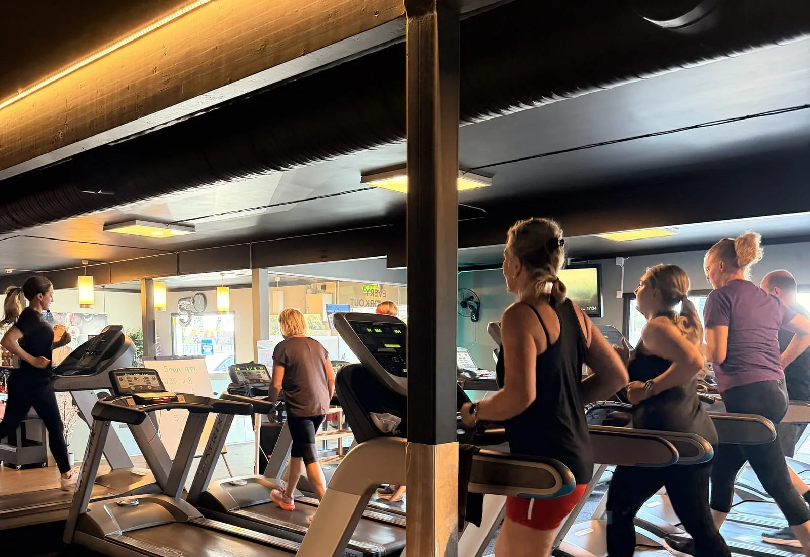 Medlemmer i gang på tredemøllene på Saltnes, i varmt lys fra taket